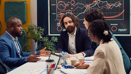 Startup team evaluating infographics data in an executive meeting, corporate restructuring or organizational changes. Adapting the organization to evolving market conditions. Camera A.