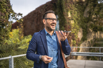 Fototapeta premium businessman stand on the terrace and left voice mail on mobile phone