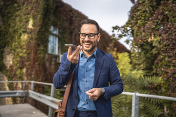 businessman stand on the terrace and left voice mail on mobile phone