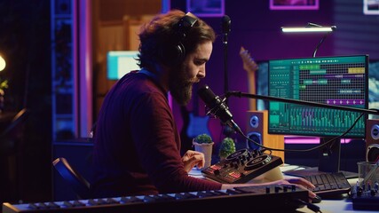Sound engineer recording backing vocals and singing on microphone, using daw software and mixing console in home studio. Artist listening to mixed tracks and create a good acoustic audio. Camera A.