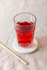 Red berries and fruits drink in the glass on the light background.