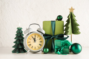 Alarm clock and Christmas decor on table against white background