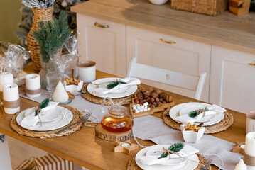 Decorated set Christmas table. Table in the kitchen. New Year decorations. Fir branches in a vase