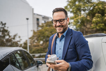 Adult businessman stand in the parking lot and use mobile phone © Miljan Živković