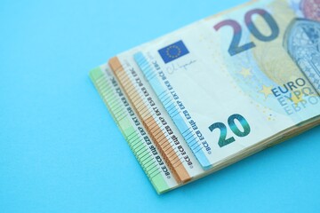 Big amount of one hundred, twenty and fifty euro money bills on blue background