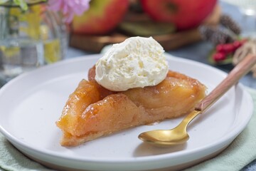 Slice of apple Tart Tartin with whipped cream, french upside down cake, horizontal