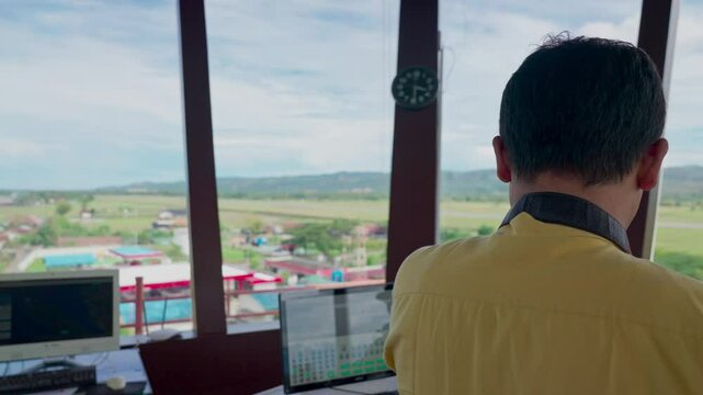 Air traffic controllers observe airport activity. Air traffic controllers work in the tower