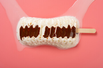 top view vanilla and chocolate flavor popsicle melting on a pink background