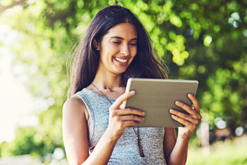 Fototapeta premium Happy woman, research and nature with tablet for eco friendly or paperless environment. Young, female person or user with smile on technology for online newspaper, article or app at outdoor park
