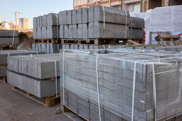 Stack of bricks on wooden pallet in front of building under construction