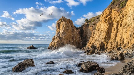 Fototapeta premium A picturesque view of a rocky coastline with crashing waves, blue sky, and seagulls flying overhead.