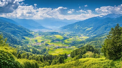 Naklejka premium A panoramic view of a valley surrounded by lush green mountains and blue skies with white clouds.
