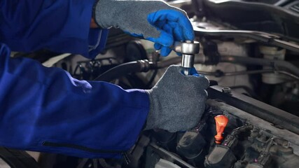 Close up mechanical hand with tools and spanner. Hispanic latin male mechanic repairs car in garage. Car maintenance and auto service garage concept