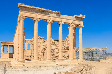 Obraz premium The ruins of a building with columns and a blue sky in the background, Acropolis in Athens