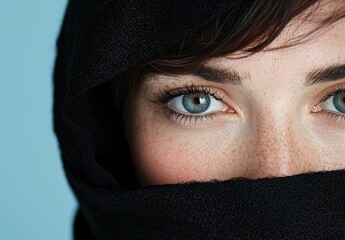 Fototapeta premium Close-up of a person's eyes and face covered by a black scarf