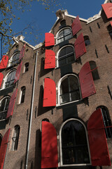 Opened windows of canal houses with red shutters in Jordaan - 3