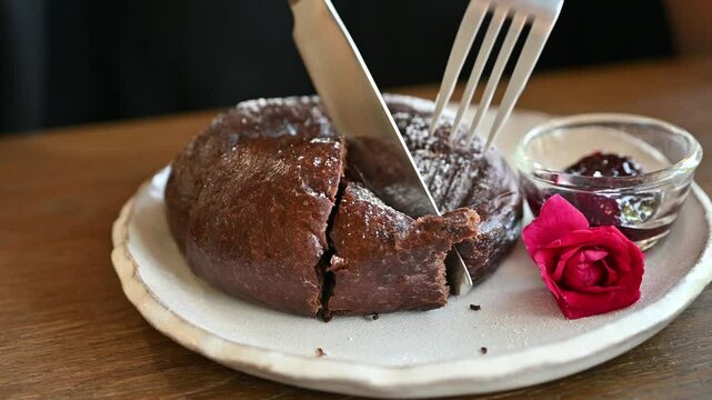 Someone cutting a pieces of choco bagel before eating. Bagel, doughnut-shaped yeast-leavened roll that is characterized by a crisp, shiny crust and a dense interior.