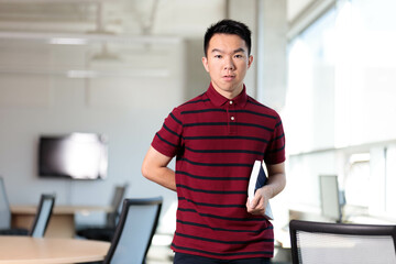 An awkward nerd student holding a book in the school library