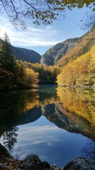 Obraz premium 74. A serene mountain landscape with a reflective lake surrounded by autumn foliage