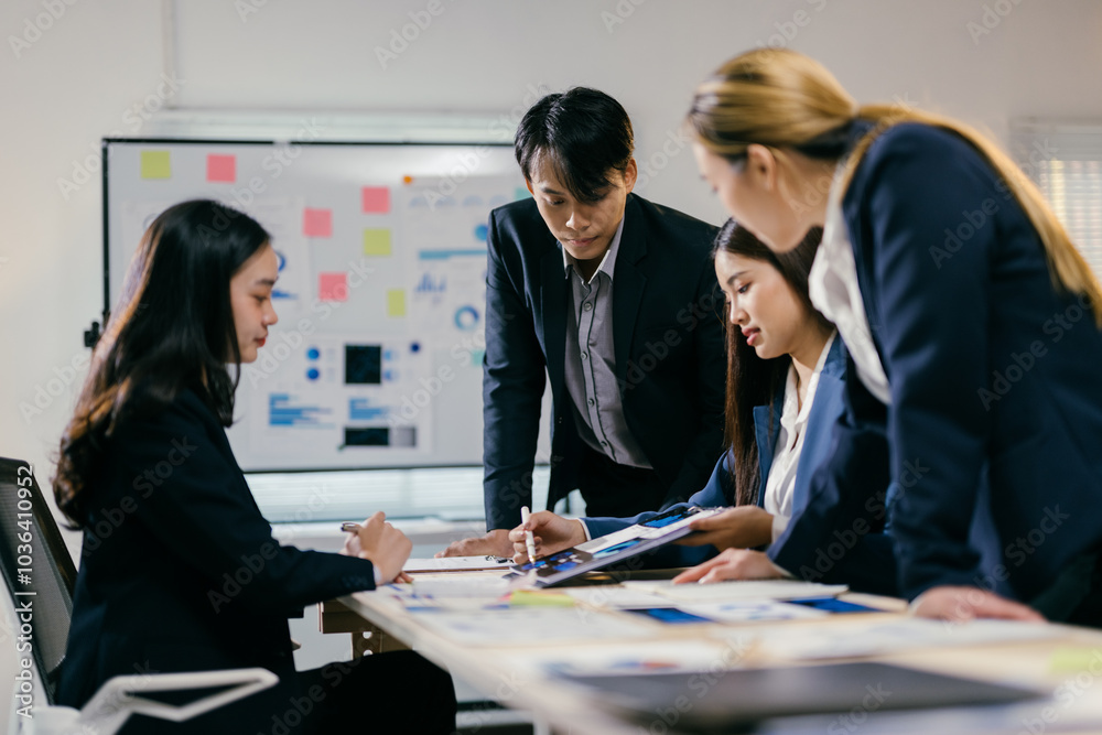 Poster team of asian professionals in business attire are gathered around a table, analyzing documents and 
