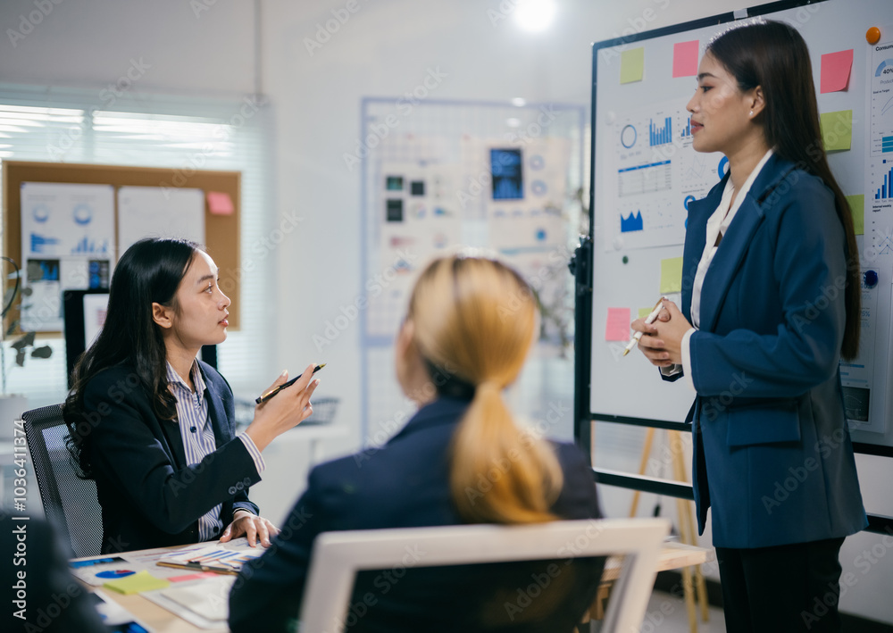 Poster businesswomen are having a productive meeting, discussing ideas and strategies while looking at a wh