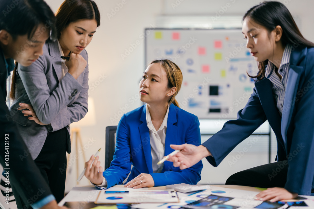 Fototapete team of asian businesspeople are discussing a project, analyzing financial documents with charts and