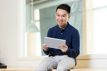 A happy young man using his tablet