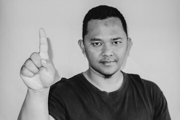 A man is raising his index finger to count one