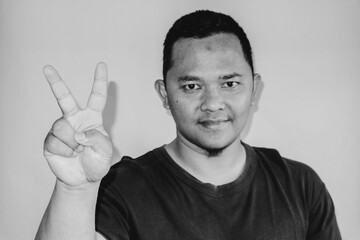 A man is raising his index finger to count two