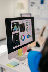 Focused businesswoman analyzes financial data on her computer, using graphs to plan for growth. Her...