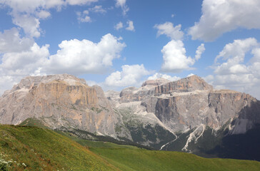 Obraz premium view of sella mountain and sass pordoi in the northern italy alps during summer with lush greenery and rocky peaks