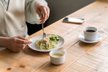 ランチでパスタを食べる女性の手元
