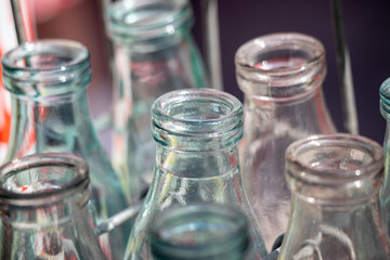 A row of empty glass bottles with the tops removed