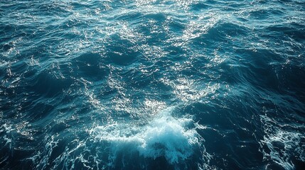 Fototapeta premium Gentle waves ripple across a serene ocean surface under bright sunlight during mid-morning hours