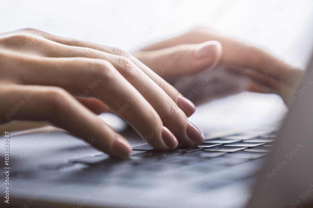 Poster the image shows a woman's hands in close-up, typing on a contemporary laptop keyboard, with a soft b