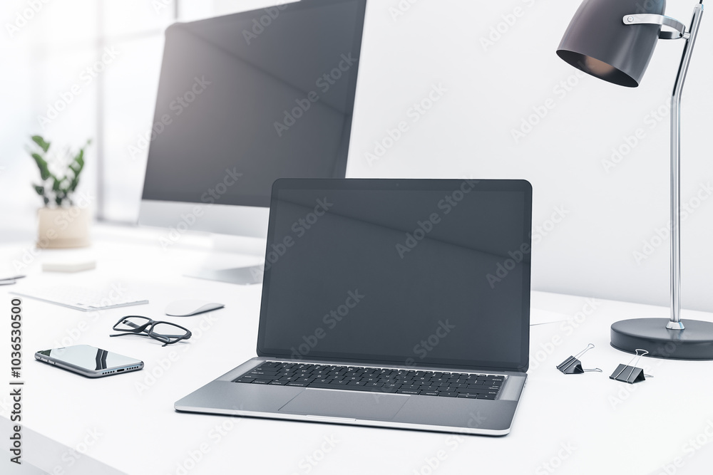 Poster Blank black modern laptop screen with reflection and copyspace for your logo or text on light table with black lamp, smartphone and computer monitor on background. 3D rendering, mockup