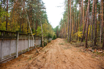 Cutting a clearing for laying an underground gas line along the fence of an enterprise