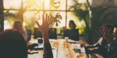Colleagues in a collaborative meeting, one member raising a hand to offer congratulations.