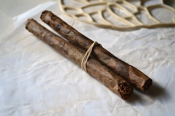 A hand-rolled cigarette lies on a pristine surface, highlighting its artisanal texture and the allure of its natural tobacco.