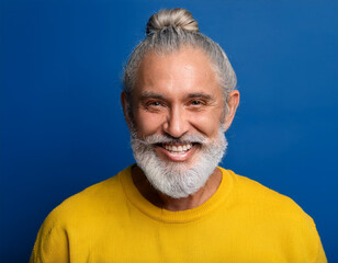 Obraz premium Portrait of Mature Handsome Man Happily Smiling Against Blue Studio Background