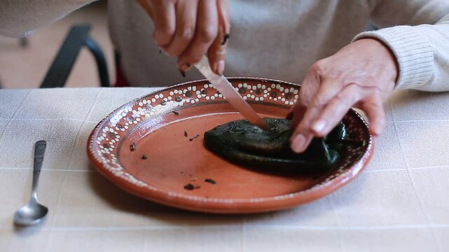 Woman cuts a poblano chili