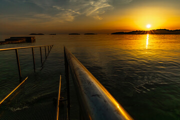 Obraz premium Guardrails, for going into the water, for wheelchairs, panorama at sunset