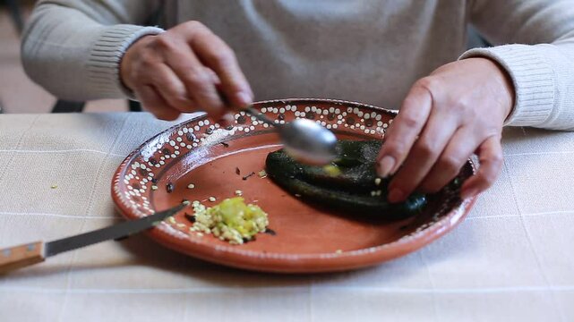 Woman cleans inside of poblano chili
