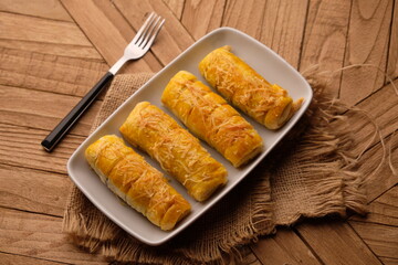 cheese roll cake on white plate on wooden table