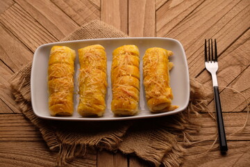 cheese roll cake on white plate on wooden table