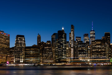 Obraz premium Manhattan skyline at night showcasing financial district lights.