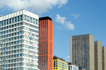Naklejka premium modern high-rise buildings with different architectural styles against background of clear blue sky.