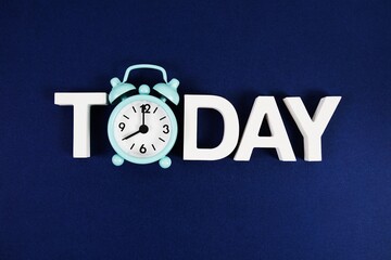 Today alphabet letters with alarm clock on navy blue background