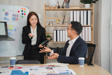 Strategic Brainstorming: A confident female business professional presents ideas to a male colleague, fostering collaboration and a positive working environment in a modern office setting.  