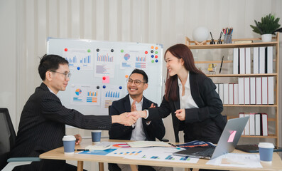 Business Deal Sealed: A handshake between two colleagues signifies a successful deal, as their...